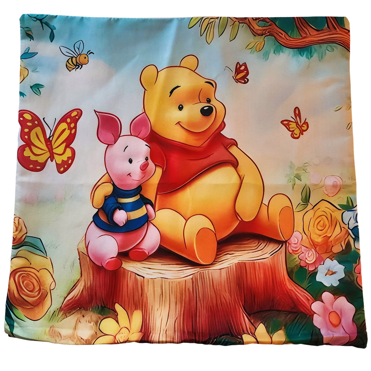 Cushion cover with Winnie the Pooh and Piglet sitting on a tree stump, surrounded by flowers and butterflies.