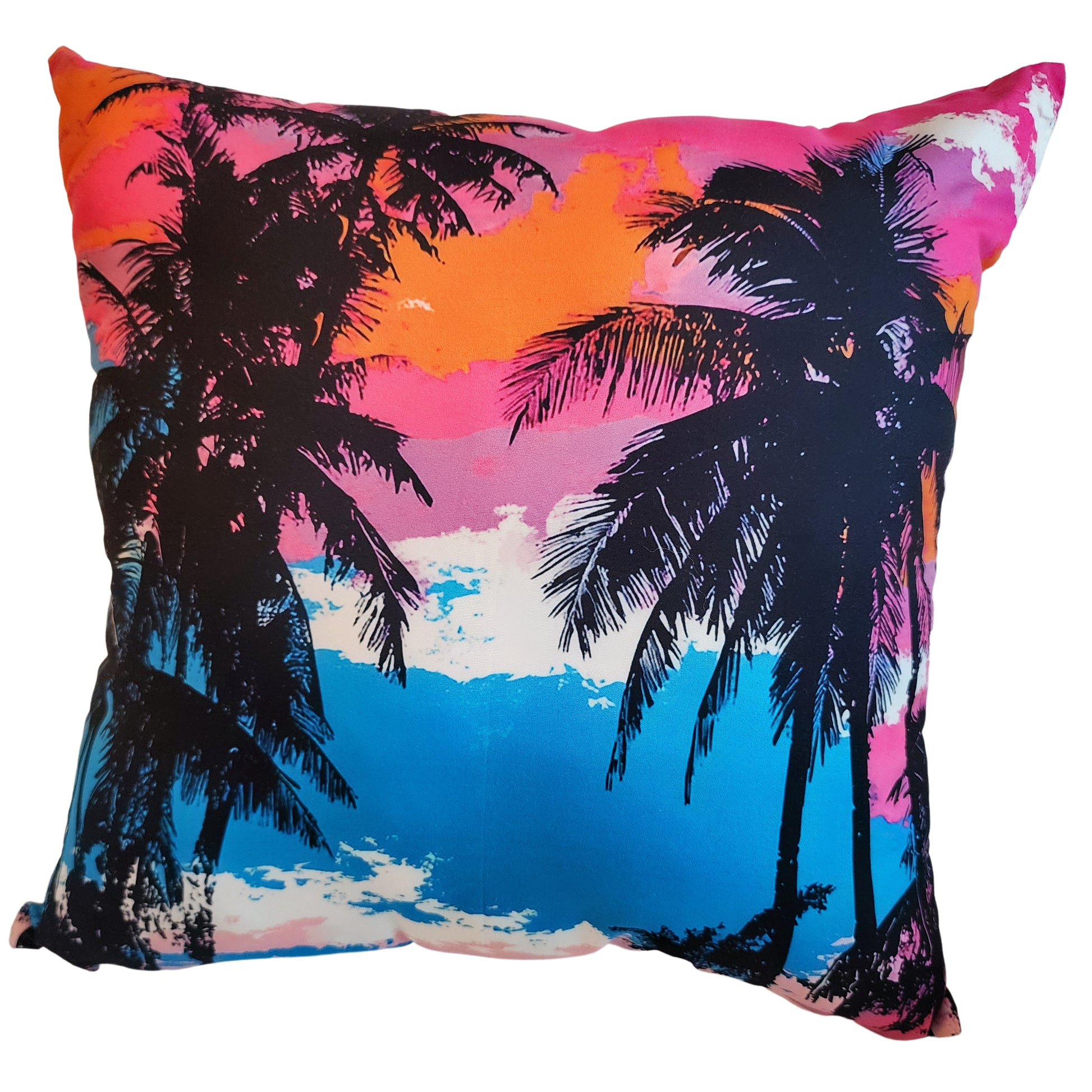 Pillow with palm tree design against a colorful sunset sky